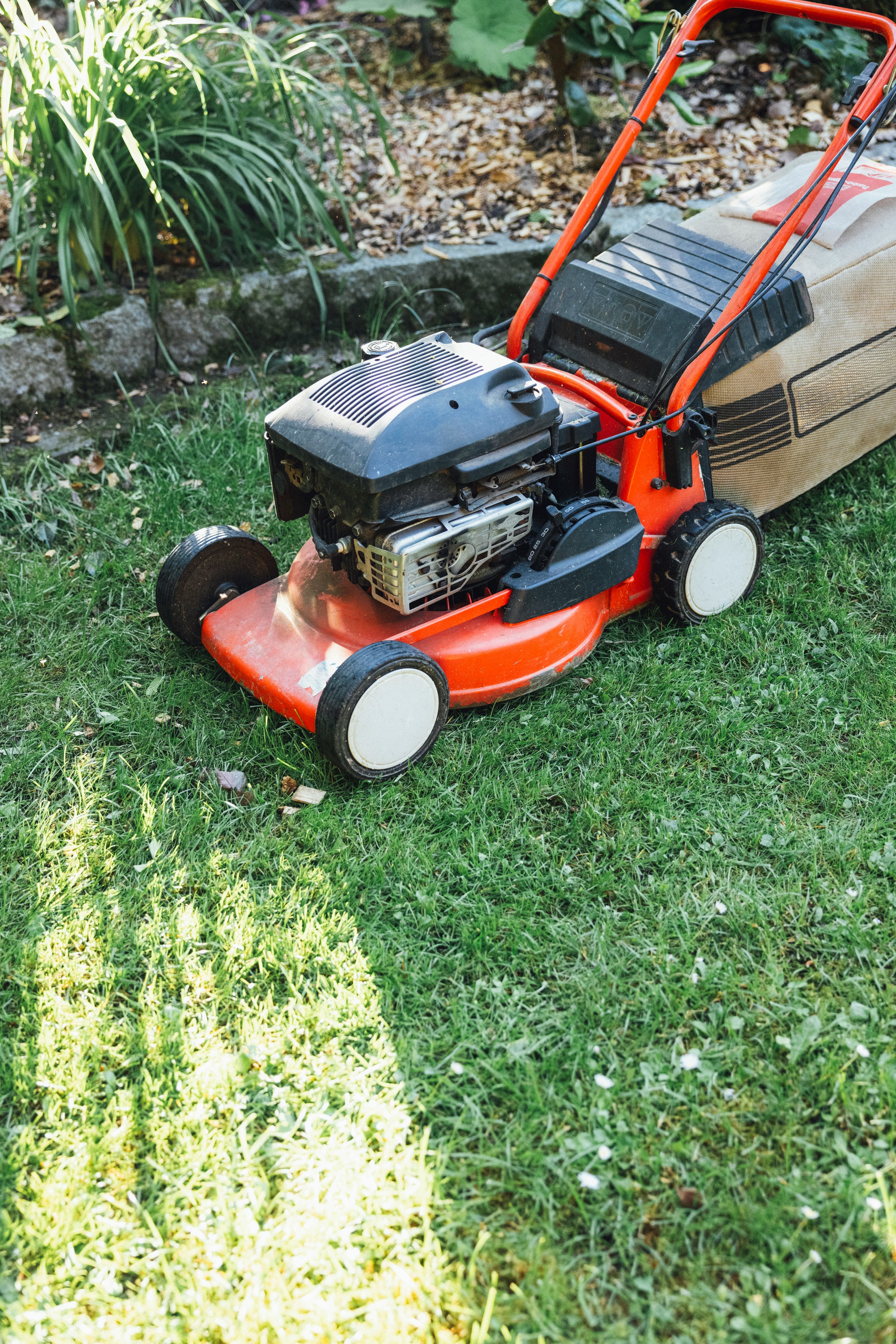 A walk-behind mower cutting a Long Island lawn.